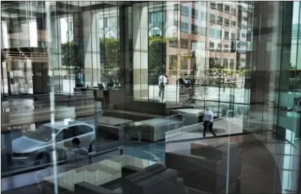  ?? RICHARD VOGEL — THE ASSOCIATED PRESS FILE ?? In this file photo, buildings and officer workers are reflected on windows in downtown Los Angeles. General Motors’ plans to cut more than 8,000 white-collar workers are a warning that few jobs are safe. Experts say technology is changing so fast that most workers will have to train for several careers during their lifetimes.