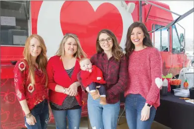  ?? MARK BUFFALO/TRILAKES EDITION ?? Brandi Hamilton, from left, Keli Colvin, Beth Nix, holding her daughter Eloise Nix, and Stephanie Goodwin pose for a picture during a community luncheon Feb. 1. The luncheon was in honor of National Go Red Day to help bring awareness of heart disease. Hamilton, who is the senior solutions specialist at ACDI in Benton, said her mom, Margaret Murray, died from heart failure in 2016.