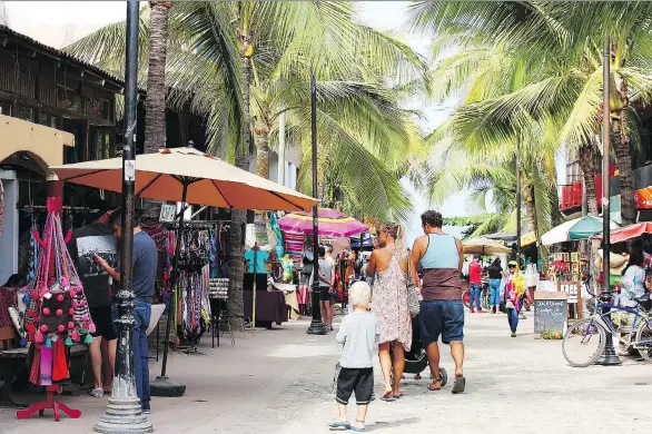  ?? PHOTOS: ELAINE O’CONNOR ?? Tourists in the Sayulita street market check out the eclectic stores featuring Huichol bead art, upcycled glass art and many other unique items.