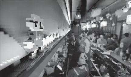  ?? KARL MERTON FERRON/BALTIMORE SUN PHOTOS ?? A likeness of Super Nintendo’s Mario is created with Lego blocks above the bar at Southern Efficiency, one of Derek Brown’s bars in D.C.