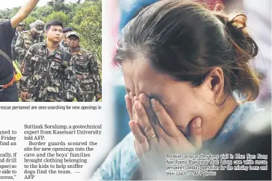  ??  ?? Two British cave-divers (second and third left) with Thai army soldiers and local rescue personnel are seen searching for new openings in the mountain of Khun Nam Nang Non Forest Park. Relatives pray as they keep vigil in Khun Nam Nang Non Forest Park near Than Luang cave while rescue personnel conduct operation for the missing teens and their coach. — AFP photos