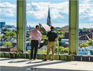  ?? ?? ABOVE: Nate Martin and Casey McFadden, of Foresight Business Solutions take in the views from the sixth floor of 615 Waterfront Drive during a Chamber of Commerce event Thursday to see progress on the Allentown riverfront developmen­t.