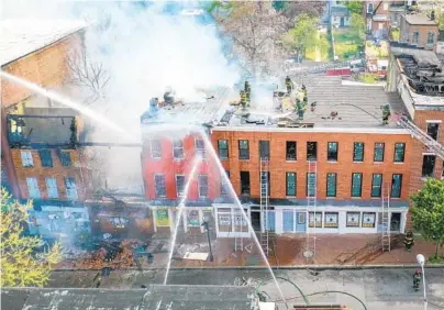  ?? JERRY JACKSON/BALTIMORE SUN ?? Firefighte­rs battle a multiple-alarm blaze Monday in the 1500 block of East Baltimore Street on Monday.