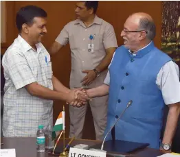  ?? — PTI ?? Delhi chief minister Arvind Kejriwal and Delhi lieutenant-governor Anil Baijal exchange greetings at the oath-taking ceremony of two new ministers at Raj Niwas in North Delhi on Friday.