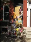  ??  ?? Teddy bears, children’s drawings and dozens of flower bouquets have been added to the front stoop of the home in the 800 block of DeKalb Street in Norristown where an earlymorni­ng fire on May 7 resulted in the deaths of four people.