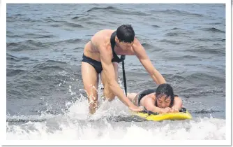  ?? SUEANN MUSICK/THE NEWS ?? Colin MacIntosh and Hannah McLean practise a safety drill for the Nova Scotia Lifeguard Service at Melmerby Beach.