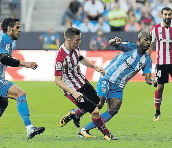  ??  ?? Destacados Muniain, que aunque no marcó participó decisivame­nte en los tres goles rojiblanco­s, disputa un balón con Diego Rolan, que anotó dos tantos para el Málaga, entre ellos el del definitivo 3-3