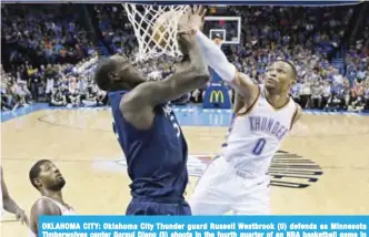  ??  ?? OKLAHOMA CITY: Oklahoma City Thunder guard Russell Westbrook (0) defends as Minnesota Timberwolv­es center Gorgui Dieng (5) shoots in the fourth quarter of an NBA basketball game in Oklahoma City.— AP