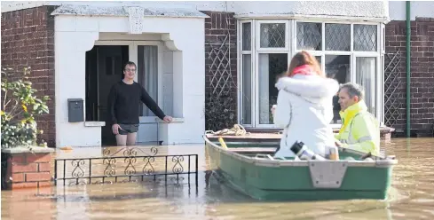  ?? AFP ?? Residents are rescued from their homes in a boat by the emergency services amid flooding in Hereford, western England, on Monday.