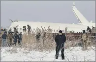  ?? PICTURE: AP ?? STANDING WATCH: Police on guard as rescuers work on the wreckage. The Kazakhstan plane crashed shortly after takeoff.