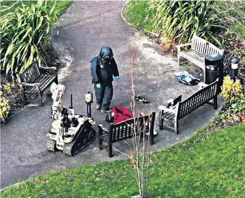  ?? ?? A police specialist approaches an abandoned red bag in the grounds of St James’s University Hospital in Leeds, above; while bomb disposal officers wait for orders after a terror alert, left