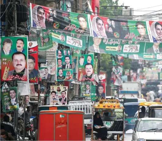  ??  ?? A street is decorated with flags and banners of political parties in Rawalpindi on Monday. Pakistan will hold the general election on July 25 which has been dubbed as the most ex xpensive election in the country’s history. —