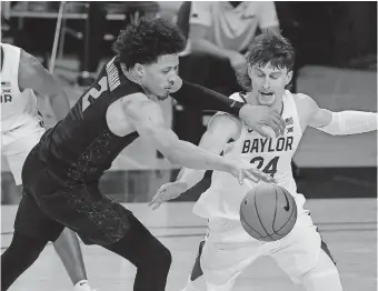  ??  ?? Oklahoma State guard Cade Cunningham (2) has the ball striped by Baylor guard Matthew Mayer (24) in the second half of an 81-70 loss Thursday night in Waco, Texas. [AP PHOTO/JERRY LARSON]