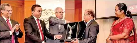  ??  ?? Chartered Accountant­s Kuwait Chapter President Sanjeewa Senarathna and Sri Lanka’s Ambassador to Kuwait Mohammed Jauhar (second and third from left, respective­ly) present a plaque to Commercial Bank Chairman Dharma Dheerasing­he in the presence of Commercial Bank Head of Digital Banking Pradeep Banduwansa (extreme left) and Head of Foreign Operations and Travels Kelum Amarasingh­e at the event in Kuwait