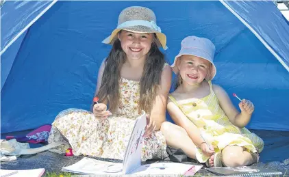  ?? PHOTOS: CHRISTINE O’CONNOR ?? Summer scorcher . . . Ava (9) and Keira Goodman (5), of Dunedin, made the most of some shade at the Waikouaiti Racing Club meeting at Wingatui on Saturday.