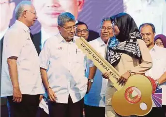  ??  ?? Prime Minister Datuk Seri Najib Razak with lucky draw winner
Noor Azie Syamira Noor Yakin at Ekspo Muafakat Kedah 2018 in Alor Star yesterday. With them is Menteri Besar Datuk Seri Ahmad Bashah Md Hanipah (second from left).