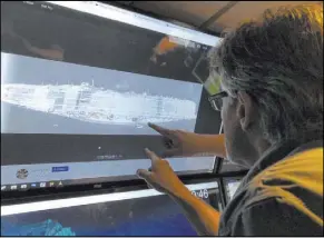  ?? Caleb Jones The Associated Press ?? Rob Kraft, Vulcan Inc. director of subsea operations of the Petrel, looks at images Wednesday of the Japanese aircraft carrier Kaga, off Midway Atoll in the Northweste­rn Hawaiian Islands.