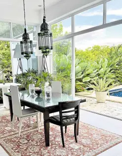  ?? ?? Moroccan lamps hover over the vintage dining table with old and modern chairs. The lush landscape makes the best focal point.