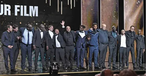  ??  ?? French director Ladj Ly (seventh right) poses on stage with cast members and producers after “Les Miserables” won the Best Feature Film award during the 45th edition of the Cesar Film Awards ceremony at the Salle Pleyel in Paris. — AFP photos