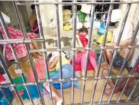  ?? SUNSTAR FOTO / ARNI ACLAO ?? LOCKEDUP. Army personnel share a detention cell with civilians at the Guadalupe Police Station after they were arrested for possession of drug parapherna­lia.