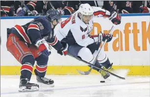  ?? AP PHOTO ?? Washington Capitals left wing Alex Ovechkin, right, skates with the puck against New York Rangers right wing Jayson Megna Saturday in New York.