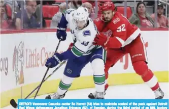  ??  ?? DETROIT: Vancouver Canucks center Bo Horvat (53) tries to maintain control of the puck against Detroit Red Wings defenseman Jonathan Ericsson (52), of Sweden, during the third period of an NHL hockey game, in Detroit. — AP