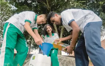  ?? FOTO CAMILO SUÁREZ ?? En el colegio República del Uruguay, estudiante­s realizan tareas de envasado para luego entregar el aceite al reciclaje.