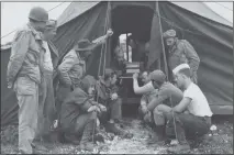  ?? USAF PHOTO ?? During World War II, airmen of the 443rd Signal Constructi­on Battalion stationed on Okinawa, Japan, listen to an Armed Forces Radio Service broadcast about the end of the hostilitie­s in Europe, May 8, 1945.