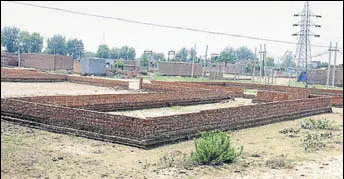  ?? SANJEEV KUMAR/HT ?? Illegal plots carved out by land mafia over the 19 acres of Wakf Board land on the outskirts of Bathinda; and (right) member of a family fleeced by the land mafia with household items kept in the courtyard in the wake of flooding caused by a canal...