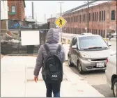  ?? Melia Russell / San Francisco Chronicle ?? A person wearing a Juul backpack walks toward the e-cigarette maker’s headquarte­rs on Pier 70 along the San Francisco, Calif., waterfront in December.