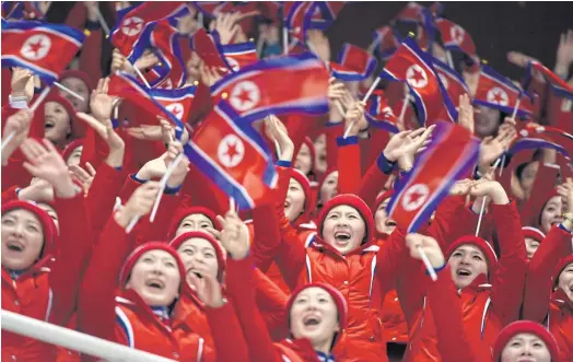  ??  ?? PATRIOTIC DISPLAY: North Korean cheerleade­rs react to the results of Ju Sik-kim and Tae Ok-ryom in the pairs figure skating competitio­n, Feb. 14.