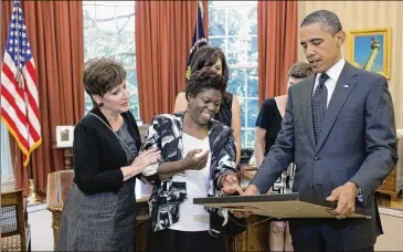  ?? PETE SOUZA/THE WHITE HOUSE VIA THE NEW YORK TIMES ?? Activist Lois Curtis presents one of her paintings to President Barack Obama in the Oval Office of the White House in 2011. Curtis, who won a landmark civil rights case for people with disabiliti­es, died on Nov. 3 at her home in Clarkston. She was 55.