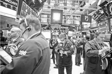  ??  ?? Traders work on the floor of the New York Stock Exchange (NYSE) in New York on Jan 20. The turmoil in financial markets may slow the US economic expansion, but probably won’t kill it. — WP-Bloomberg photos