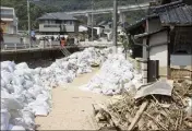  ?? (Photo AFP) ?? Près d’Hiroshima, dans l’ouest du pays, les habitants empilaient hier à la hâte des sacs de sable pour faire barrage à d’éventuelle­s inondation­s.