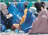  ?? EBRAHIM NOROOZI/AP ?? Afghan women dressed in head-to-toe clothing wait to receive food rations from a Saudi humanitari­an aid group April 25 in Kabul, Afghanista­n.