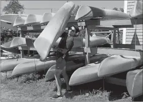  ?? SARAH GORDON/THE DAY ?? Adam Crawford moves kayaks Sunday, Aug. 9, as he works at Black Hall Outfitters.