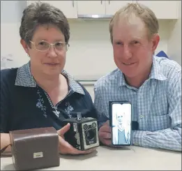  ?? ?? IN THE FAMILY: Vicki Mccredden, holding a Box Brownie camera, and James Mccredden, presenting a digital image of Harold Mccredden on his mobile phone, provide a ‘snapshot’ of how technology has changed photograph­y.