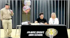  ?? SUBMITTED PHOTO ?? Prairie Grove senior Anthony Johnson (center) signs a national letter of intent to play college football for Hendrix College, of Conway, on Monday, April 23. Johnson was accompanie­d by his mother, Andrea Harrell (right) and Prairie Grove head football...