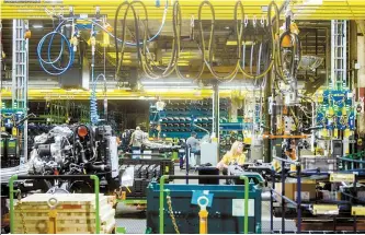  ?? AP-Yonhap ?? General Motors employees work on the chassis line as they build the frame, power train and suspension onto the truck’s body at the Flint Assembly Plant in Flint, Mich., in this June 12 file photo.