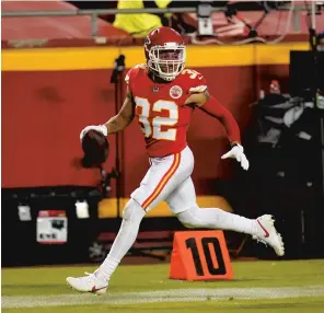  ?? JEFFROBERS­ON/AP ?? Chiefs safety Tyrann Mathieu (32) runs from Patriots wide receiverJu­lian Edelman, right, while returning an intercepti­on for a touchdown during the second half of Monday’s gamein Kansas City.