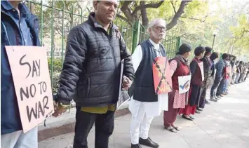  ??  ?? Protesters hold hands to form a human chain during an anti-war demonstrat­ion called by pacifist organisati­ons in New Delhi on Monday. — AFP