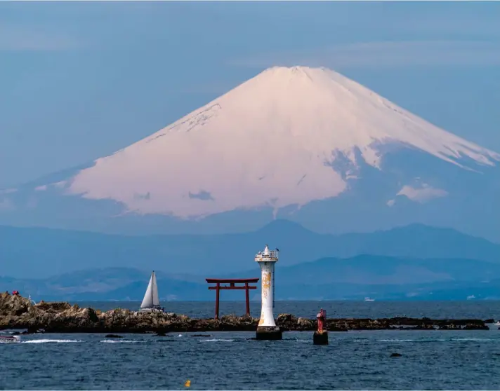  ?? ?? Mount Fuji appears behind a Torii gate, an entrance gate to a Shinto shrine, in Sagami Bay Wednesday, April 6, 2022, in Zushi, south of Tokyo. Photo: AP