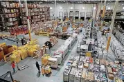  ?? [AP FILE PHOTO] ?? Workers prepare to move products at an Amazon fulfillmen­t center in Baltimore in this 2017 photo. Amazon is paying workers to defend the company on Twitter, reassuring critics that they make enough money to live and are allowed to take bathroom breaks. The tweets are part of Amazon’s plan to combat negative headlines and online chatter about poor working conditions at its warehouses.