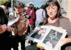  ?? /ARCHIVO ?? Una mujer muestra fotos de ella y el cura que, dice, la abusó cuando era una adolescent­e.