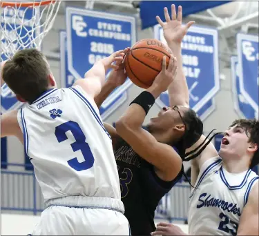  ?? MATTHEW B. MOWERY — MEDIANEWS GROUP ?? Warren De La Salle’s Phoenix Glassnor, center, drives between Detroit Catholic Central defenders Asher Suardini, left, and Josh Ross in the second half of a Catholic High School League Central Division boys basketball game on Tuesday.