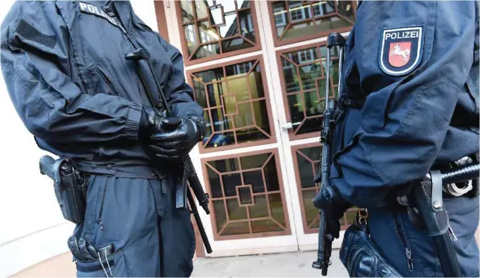  ?? — AFP ?? CELLE: Policemen secure an entrance to the Higher Regional Court in Celle near Hanover, northern Germany, where a verdict was expected against suspected jihadist girl Safia S. Safia S accused of stabbing a police officer, an assault allegedly ordered...