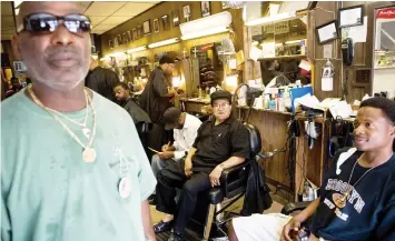  ?? FRANCE PRESSE
AGENCE ?? In this file photo, Nurney Mason (center) of Washington, DC, sits alongside customers in his son's barbershop at Mason's Hair Gallery, a barbershop and hair salon, in Washington,DC. Black barbershop­s are known as places to gather, socialize and get a...