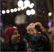  ?? STAFF FILE PHOTO ?? Nathan Cruz and son Mason, 18months, of San Jose, stand under falling artificial snowflakes at Christmas in the Park.