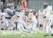  ?? SHERRY LAVARS — MARIN INDEPENDEN­T JOURNAL, FILE ?? From left to right, Marin Catholic defender Daniel O’Leary is blocked by San Marin’s Justin Guin as teammate Aidyn Gendel carries the ball during their MCAL game in Kentfield on Oct. 23.