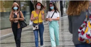  ?? Associated Press ?? People wearing face masks Monday to protect against coronaviru­s walk along the Champs Elysees avenue in Paris.
